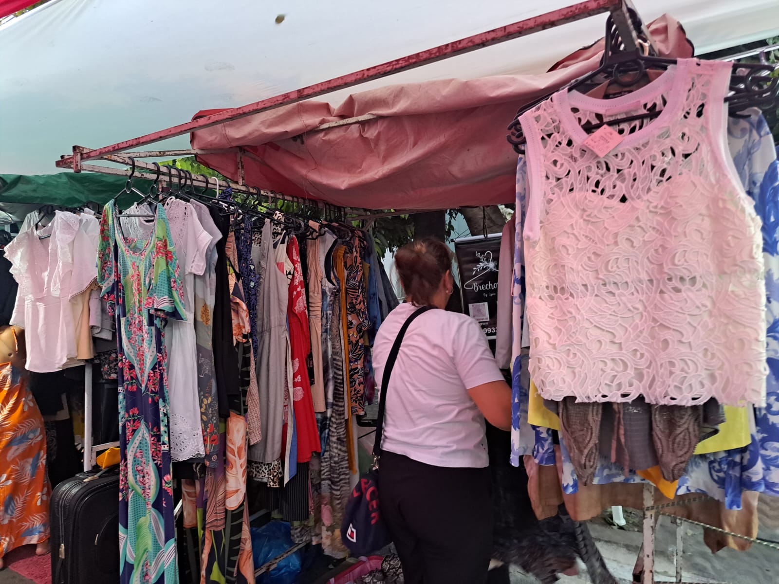 Banca de um dos brechós participantes com diversas peças de roupa