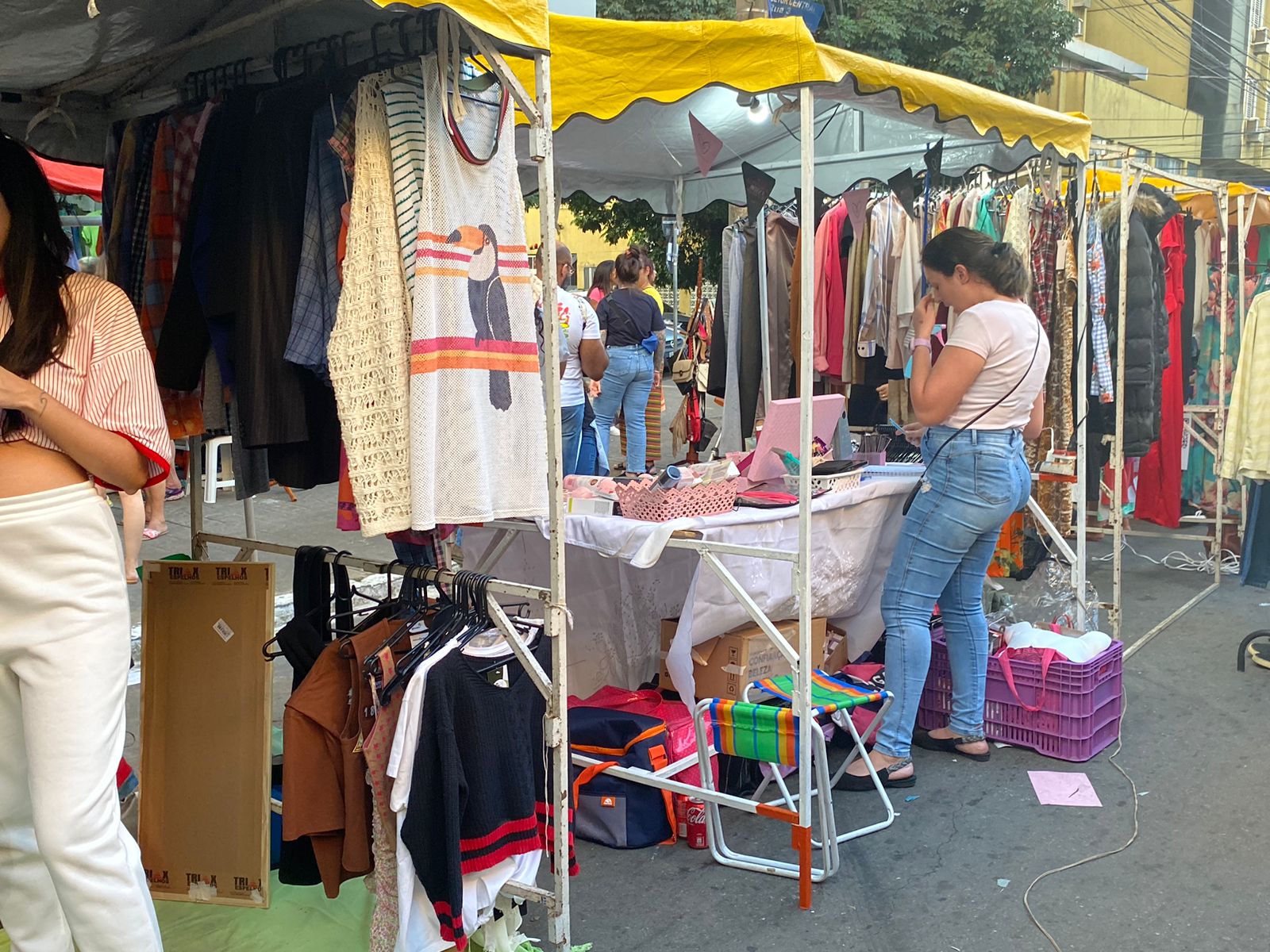 Visão de algumas bancas com opções de roupas e cosméticos